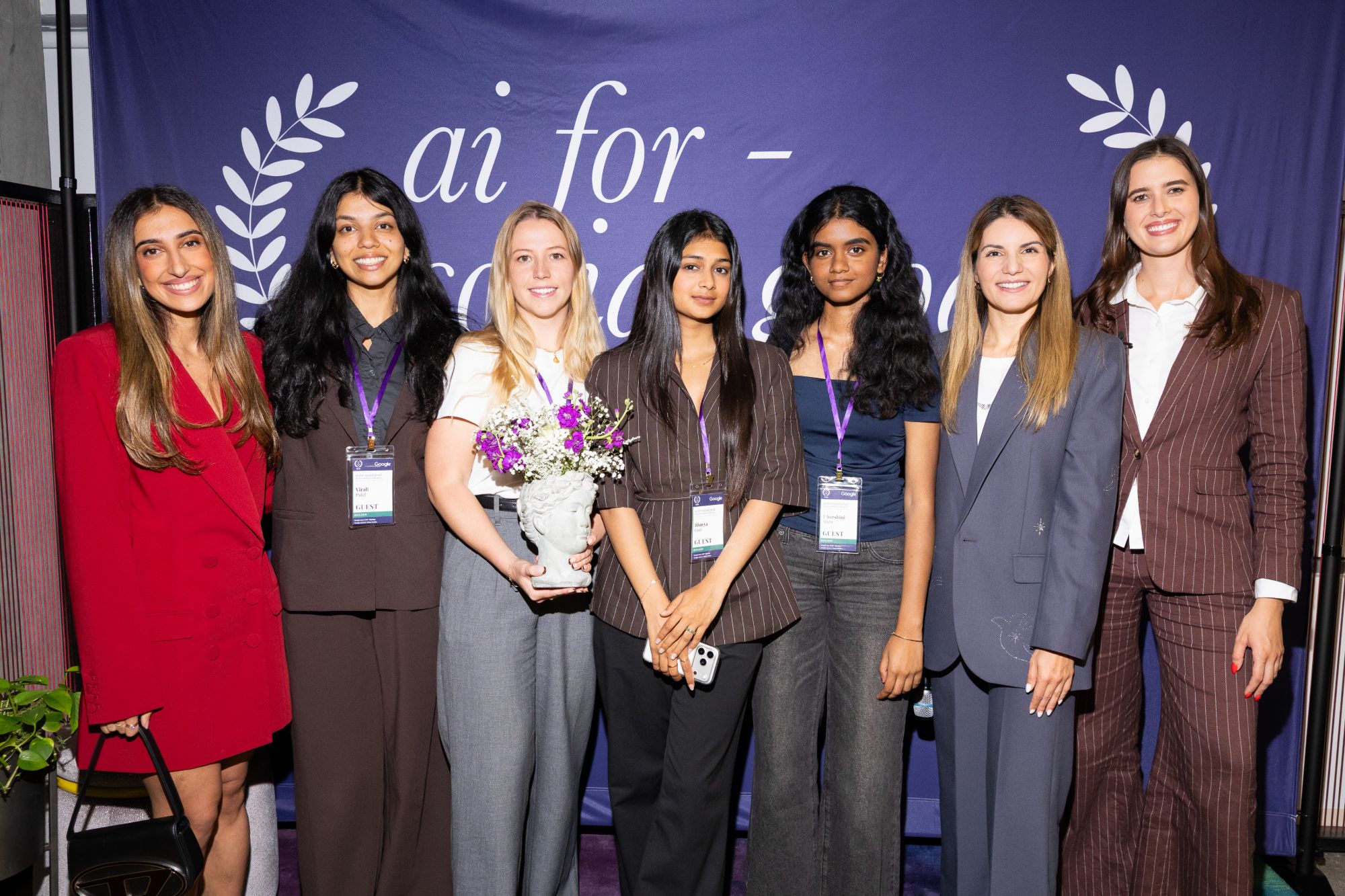 The Reclaim team holding the first-place trophy with the judges, in front of the AI for Social Good backdrop