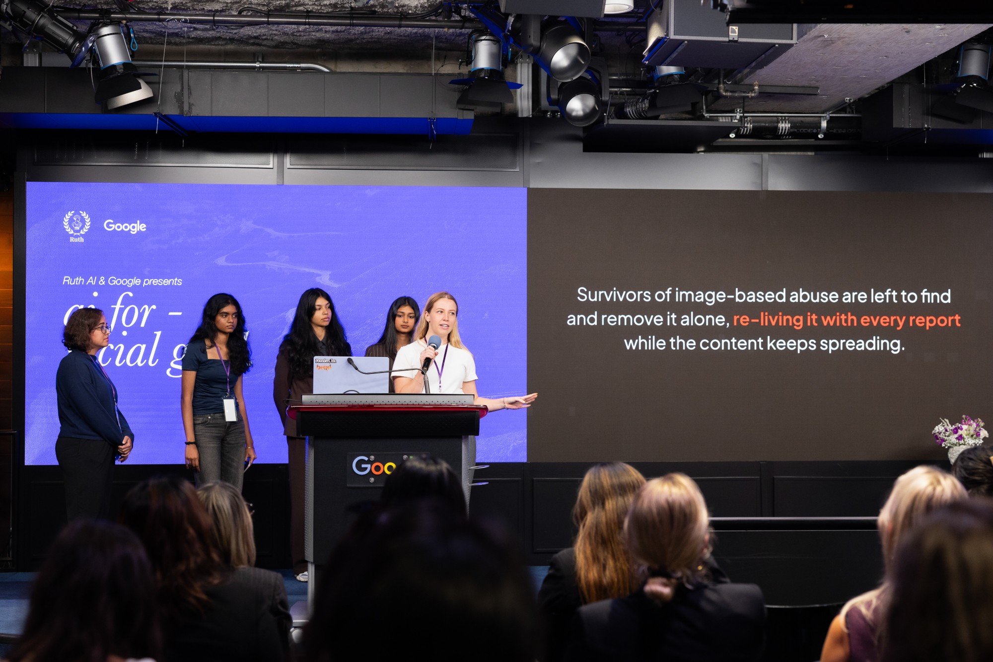 The Reclaim team pitching at the podium beside a slide about survivors of image-based abuse